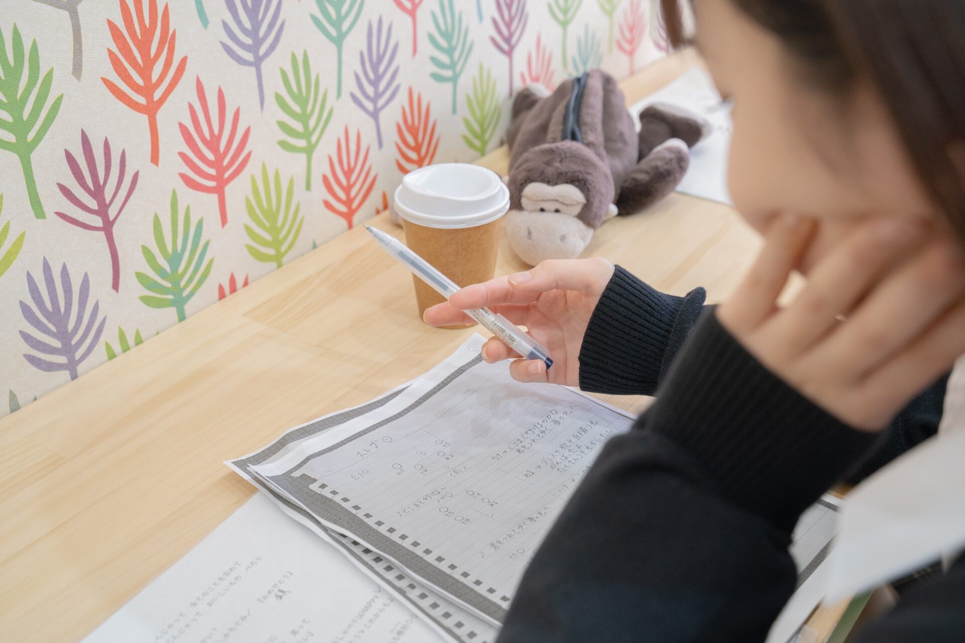放課後のカフェでノートを開いて勉強する学生
